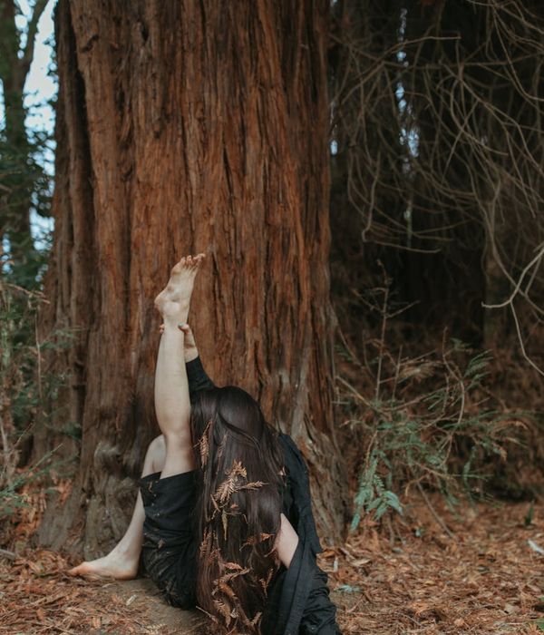 Woman performing a gentle, mindful movement in a calm setting.